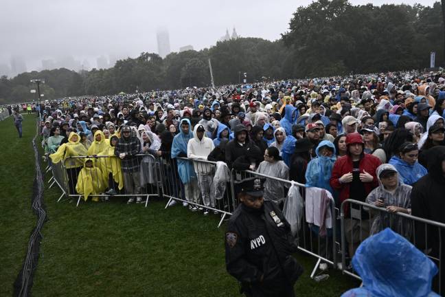 Festivalgoers stand in the rain during the Global Citizen Festival on Saturday, Sept. 28, 2024, in Central Park in New York.