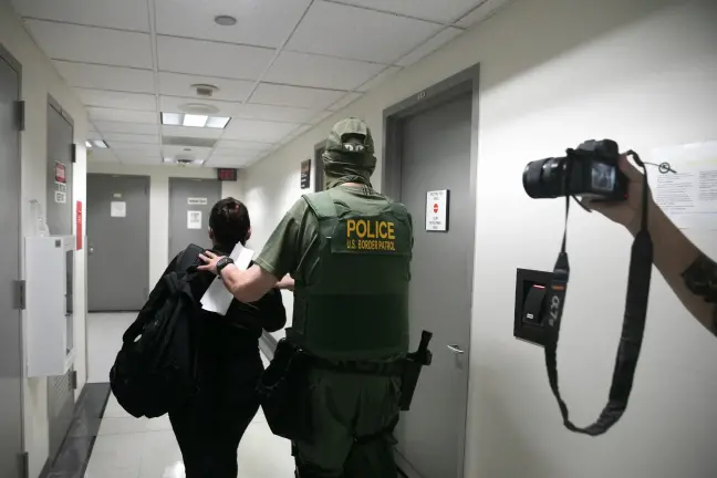 A U.S. Border Patrol agent is seen detaining a woman within the Federal Plaza immigration courthouse Aug. 7, 2025.