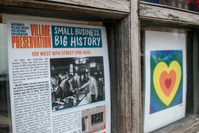 A printout of a Greenwich Village Society for Historical Preservation article, featuring the famous photograph of the 1966 “Sip-In,” taken by Fred McDarrah, hangs in the window of Julius’ Bar. Photo: Leah Foreman