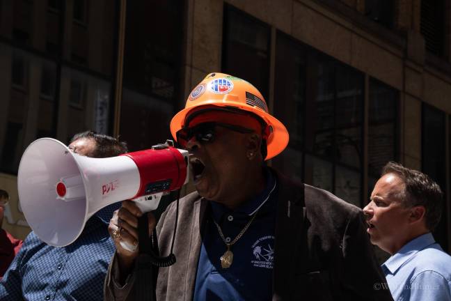 Anthony Williamson, Local 79 spokesperson, leading a chant on July 9, blasting the non-union developers behind the troubled building.