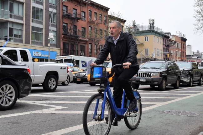 A cyclist rides in the protected bike lane on Eighth Avenue near 26th Street. Under a new proposal, DOT would install a southbound protected lane on Seventh Avenue. Photo: Michael Garofalo