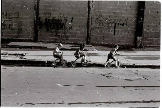 Three kids ride their tricycles down a Lower East Side street (1980). Photo courtesy of Alex Harsley