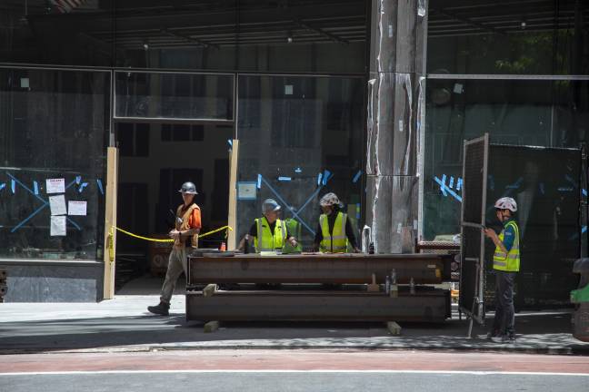 A construction crew arrives at the old Pfizer HQ with new support beams.