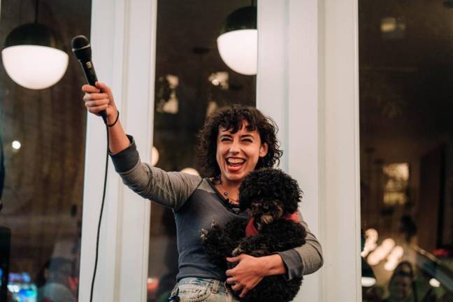 Comic Blair Dawson holding an audience member’s pup. Photo: David Kirchner