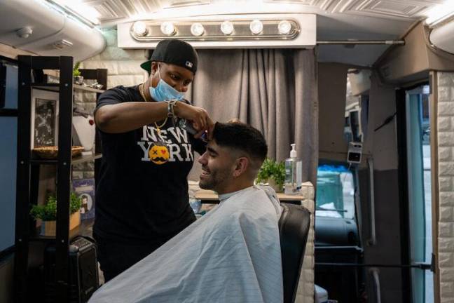 Young gives client Victor Munoz, 30, a haircut. “I saw the flag here and knew that I had to come here,” he said. “It is so inclusive.” Photo: Nathan Morris