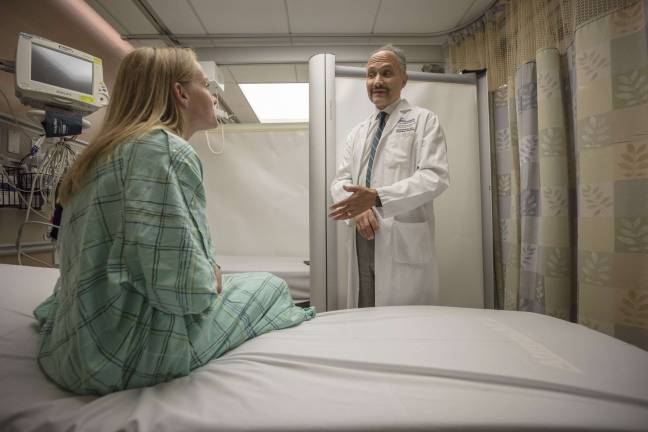 Dr. Rob Femia, chair of the Ronald O. Perelman Department of Emergency Medicine at NYU Langone Health, discusses treatment with a patient in the emergency room. Photo: Andrew Neary