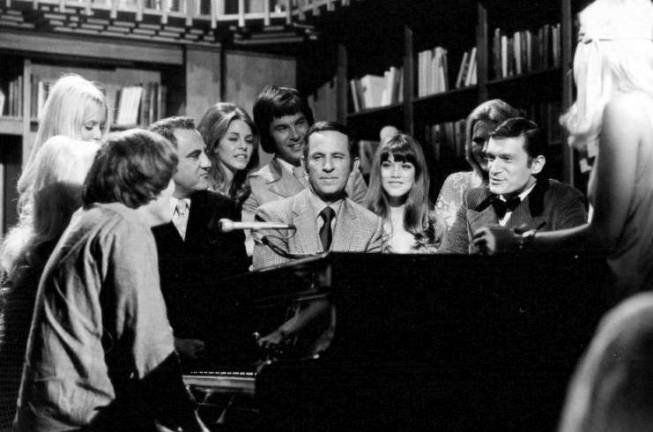 A 1970 press photo for the syndicated TV show "Playboy After Dark," which was in taped in Los Angeles. Hugh Hefner (in tuxedo) is at far right, actor-comedian Don Adams, who played Maxwell Smart, also known as "Agent 86," in the comedy "Get Smart," is at center, and Playboy cover girl and longtime Hefner girlfriend Barbi Benton is seated between them. Photo: Playboy Enterprises, via Wikimedia Commons