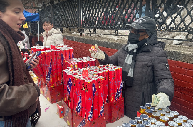 A vendor of confetti sticks does a brisk business at the Lunar New Year kickoff.