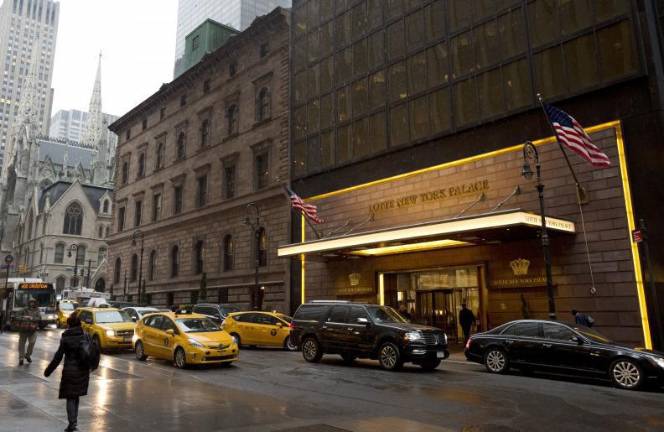 Traffic passes St. Patrick's Cathedral, left, and the Lotte New York Palace Hotel, Wednesday, March 1, 2017. The Archdiocese of New York is seeking a $100 million short-term mortgage on property it leases to the hotel. The money is for victims of clergy sexual abuse. (AP Photo/Mark Lennihan)