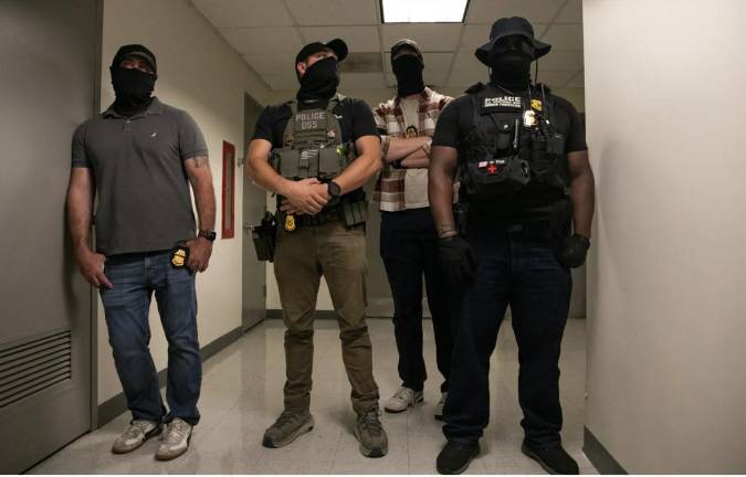 Federal agents guard a stairwell while their colleagues detain people leaving immigration court inside 26 Federal Plaza, Aug. 7, 2025.