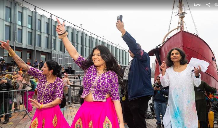 Dancers in native costumes take the stage with the Abu Seghal (for right) a driving force behind the growing Holi festival and Jonathan Boulware, the president of the South Street Seaport Museum.