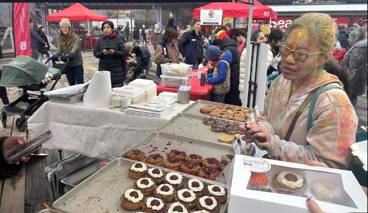 She’s ready to sell you some sweets as vendors of Indian food became a big part of this year’s Holi Festival.