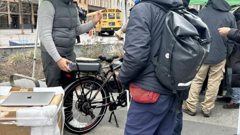 Stephan Von Wolff, CEO of Swobbee (left), signing up a delivery worker (right), who just registered, to swap out batteries with Swobbee on March 7 at the pilot program in Cooper Square in the East Village. Photo Credit: Alessia Girardin.