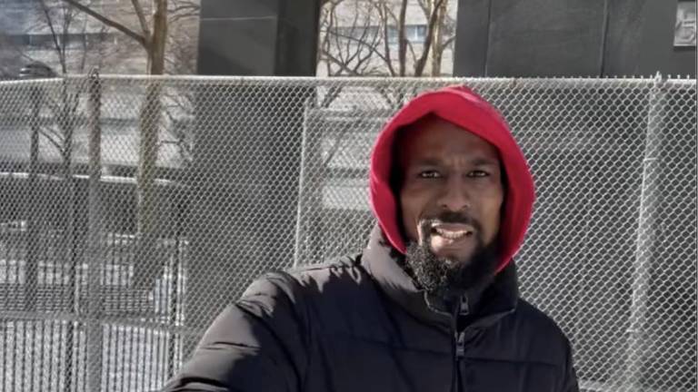 Aspiring politician Skiboky Stora poses for selife outside 111 Centre St. during his trial.