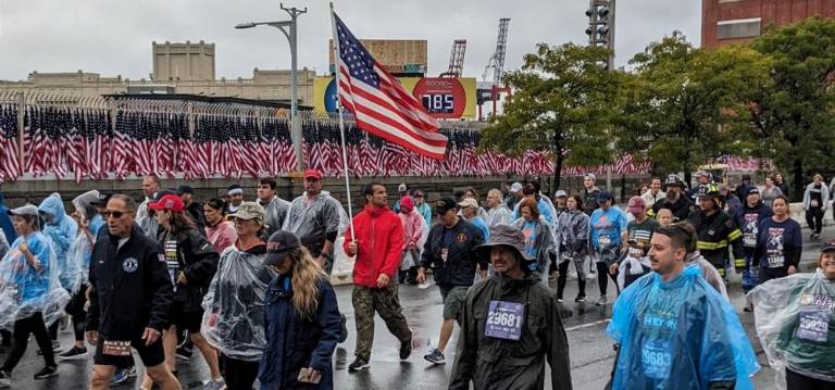 Flags representing the 343 firefighters who died on 9/11 displayed on the sideline of the 21st annual Stephen Stiller Tunnels to Tower Run on Sept. 24 which drew 40,000 participants despite the remnants of Hurricane Ophelia drenching the city. Photo: Brian Berger