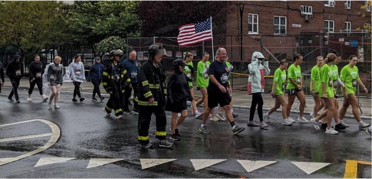 Many firefighters who retrace the steps of firefighter Stephen Stiller on 9/11 don their turnout coats and helmets during the run and walk through the Hugh L. Carey Tunnel. Photo: Brian Berger