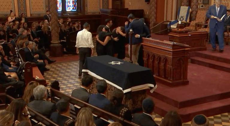 Mourners comfort one another at the Central Synagogue service for 27-year-old Julia Hyman, who became the final victim of the July 28 massacre at 345 Park Ave. and the first one laid to rest, on July 30.