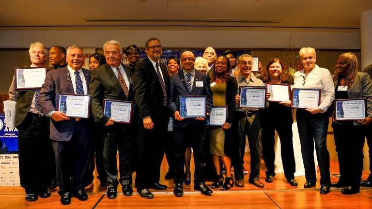 32BJ President Hector Figueroa and Straus Media-Manhattan Publisher Jeanne Straus with the 2017 Building Service Award winners. Photo: Preston Ehrler/prestonehrler.com