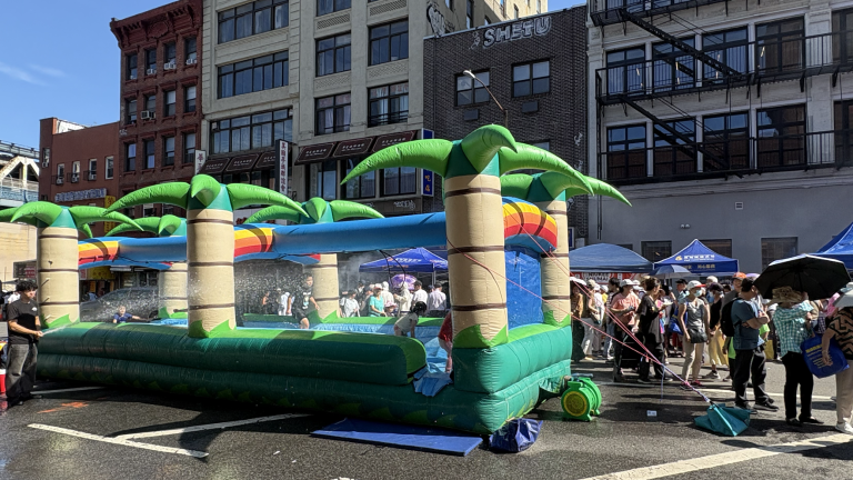 Children enjoy the water-soaked bouncy castle on Division Street, set up for the 5th Precinct and the Chinese Chamber of Commerce’s annual National Night Out (NNO) event.