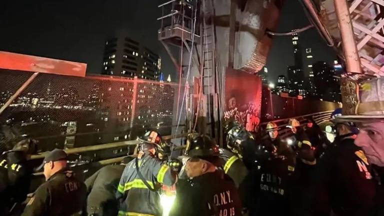 Firefighters work to rescue a teen boy who fell down a 50 ft worker’s maintenance shaft on the Queensboro Bridge on Feb. 16. Some social media posters said the boy had been lying at the bottom of the shaft for hours before 911 was called. The report is unconfirmed, but the NYPD was not releasing further details.