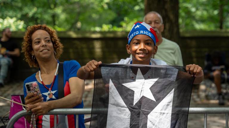 A young supporter at the Puerto Rican Day Parade flies a black and white Puerto Rican Flag; a symbol of resistance to American control.