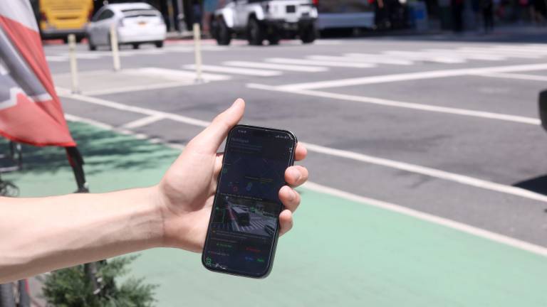 ParkSignal NYC detects open street parking spots. Eighteen-year-old Theo Darringer holds his phone in front of the free spot the app says is open.
