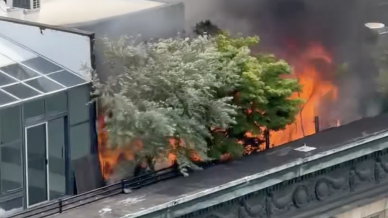 A fire on the roof of 366 Broadway blazing on the morning of June 19, visible to passerby and nearby buildfing occupants.
