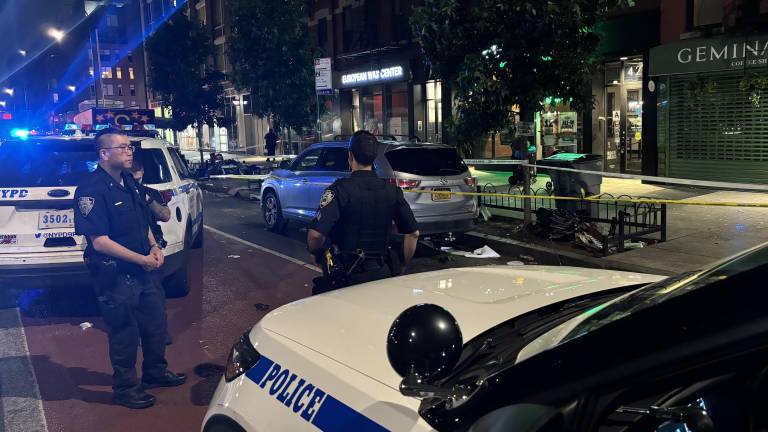 Police on E. 14th St. in July, after a violent encounter left one person dead and two others stabbed.