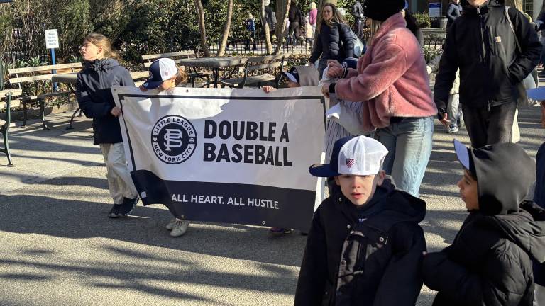 Young fans with an assist from a mom, carry the banner for the Double A division during the Peter Stuyvesant Little League parade on March 28.