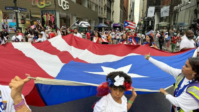 Parade-goers unfurl a giant Puerto Rican flag