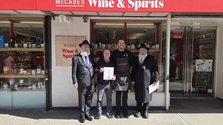 Despite the shops Celtic sounding name, McCabe’s Wine &amp; Spirits is a kosher liquor store owned by an observant Jewish proprietor Daniel Mesnik who must sell the store for the duration of Passover and then buy it back. From left: Rabbi Ben Krasnianski, Daniel Mesznik, Allen Alexis, Rabbi Kalman Weinfeld