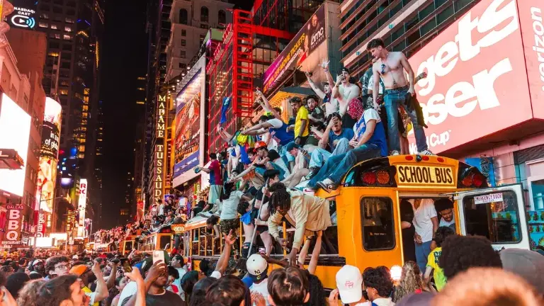 Fans climbed atop five school buses that were set aside to transport people from Manhattan to the World Cup games. One of the buses was later set on fire near Times Square. There were 65 arrests on the night,.