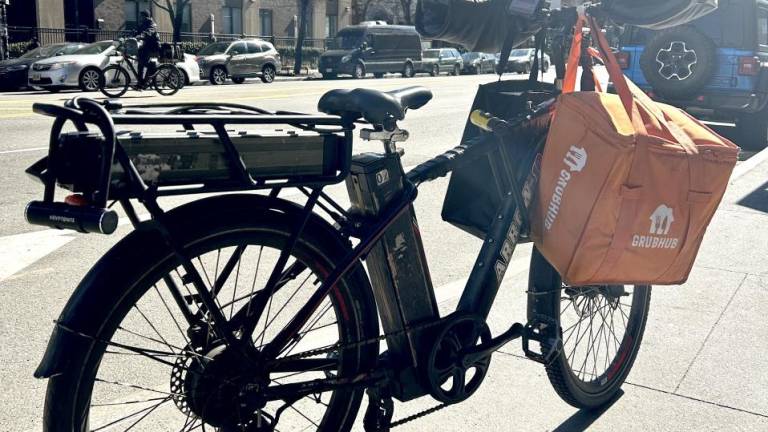 The e-bike of a Burkina Faso delivery driver who uses lithium batteries that he charges at home. Another fully charged battery is stored at the back of his bike. The pilot program hopes to lessen the residential fire danger. Photo: Alessia Girardin.