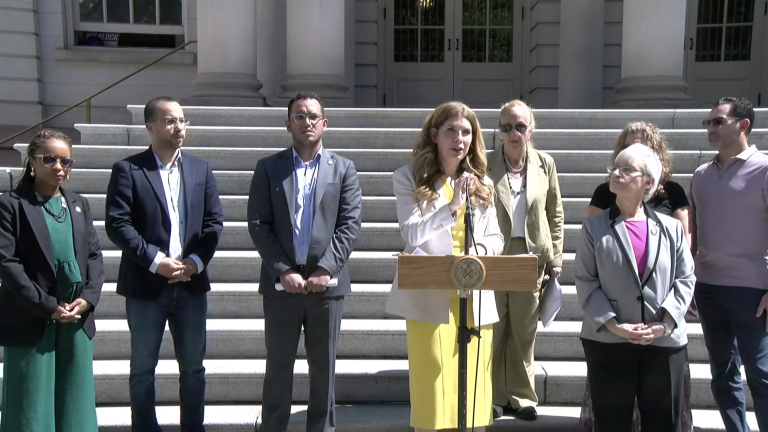 NYC Council Members on the steps of city hall, announcing a Sept. 30 hearing on e-bike safety. From left to right: Council Members Selvena Brooks-Powers, Oswald Feliz, Majority Leader Shaun Abreu, Speaker Julie Menin, Gale Brewer, and Lynn Schulman. Council Members were joined by Jessica Solano, who’s been caring for her sister after she was severely injured by an e-bike while jogging, and Solano’s husband, Brian (right).